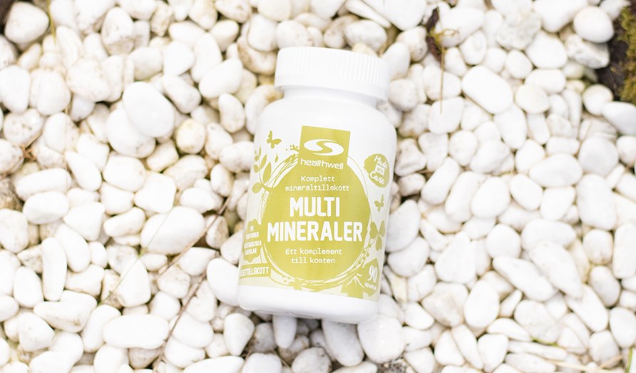 Kuva Healthwell Multiminerals -purkista, joka makaa valkoisilla kivill.